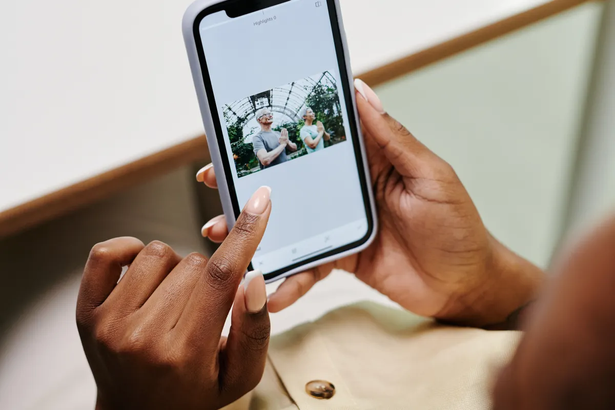 Hands holding a phone and looking closely at a photo on the screen