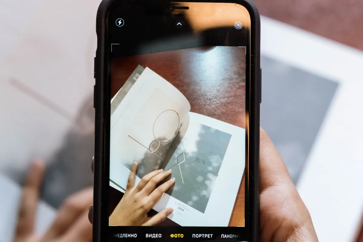 A phone camera screen framing an open printed page held flat on a table